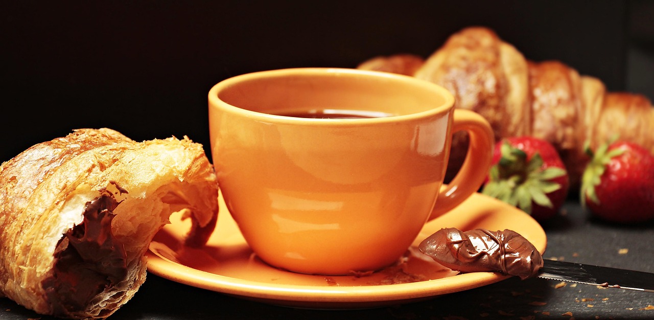 Open notitieboek naast stomende kop koffie. Open notitieboek naast stomende kop koffie.